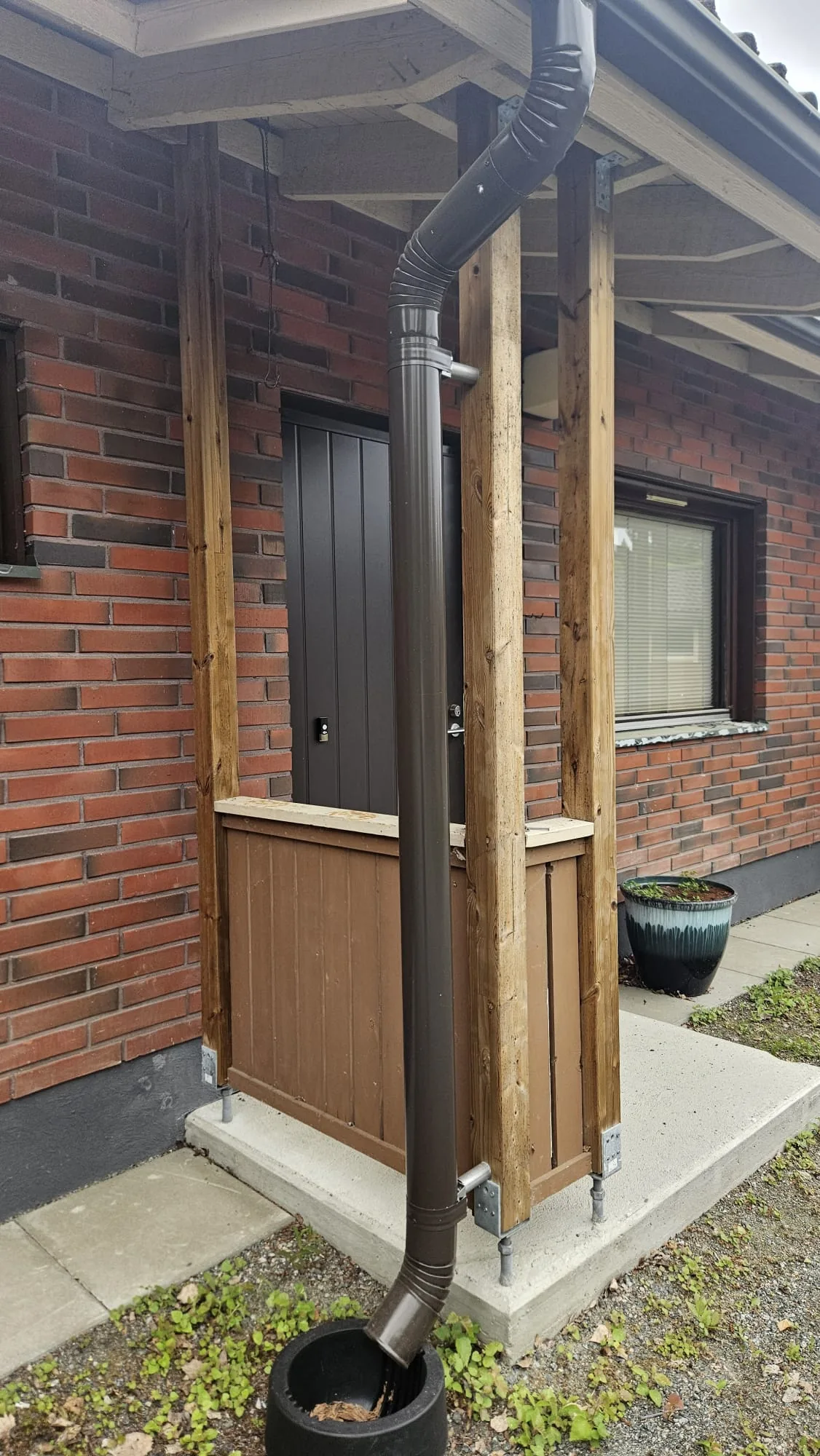 Rakennettu puinen sisäänkäyntirakenne tiilitaloon